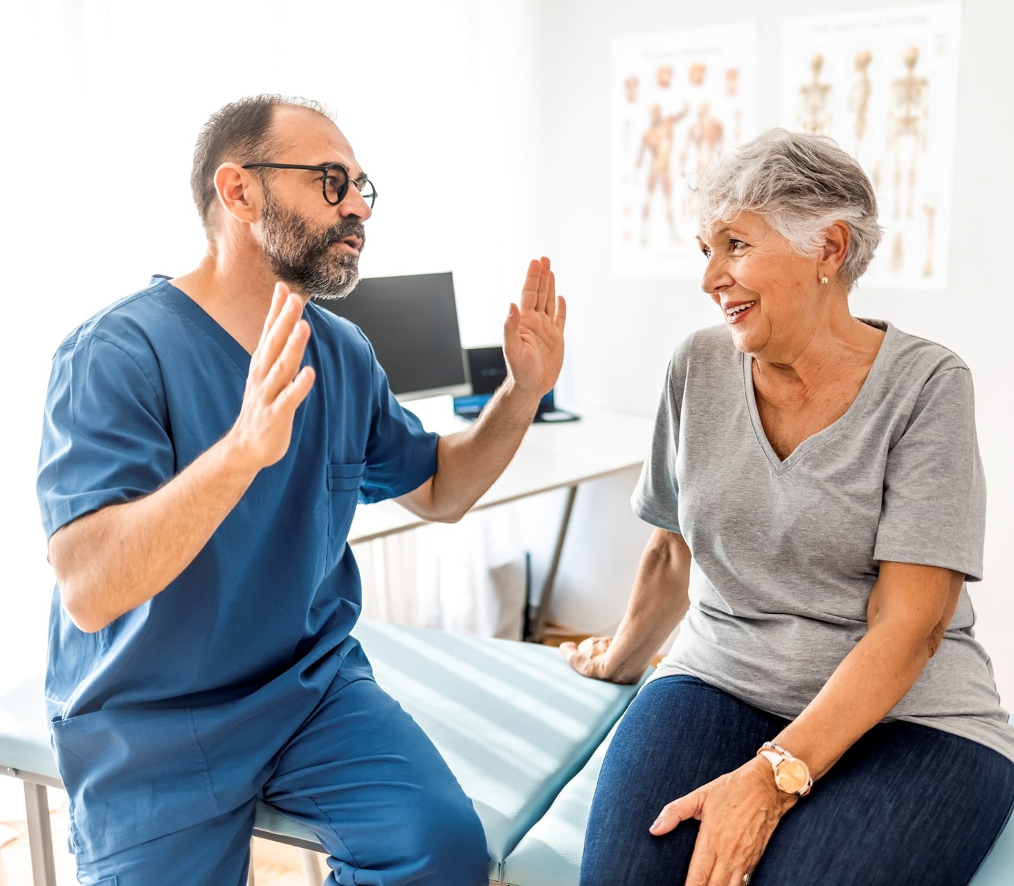 Cropped shot of a handsome mature male physiotherapist doing a consultation and assessment with a senior female patient.